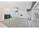 Bright living room with fireplace, carpet, and sliding glass doors leading to a balcony at 329 Sunset Way, Palm Harbor, FL 34683