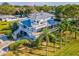 Aerial showcasing the home's side, highlighting expansive decks and lush landscaping at 329 Sunset Way, Palm Harbor, FL 34683
