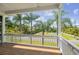 Porch with white railings offering view of palm trees and tennis court at 329 Sunset Way, Palm Harbor, FL 34683