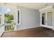 Large covered porch with wood flooring and access to home at 329 Sunset Way, Palm Harbor, FL 34683