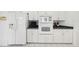 Kitchen features white appliances and cabinetry, granite countertops at 329 Sunset Way, Palm Harbor, FL 34683