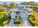 Aerial view of a two-story home with a large yard, double garage, and deck at 329 Sunset Way, Palm Harbor, FL 34683