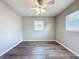 The bedroom has wood flooring and is lit by a ceiling fan and two windows at 1513 55Th N Ave, St Petersburg, FL 33703