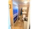 Small bathroom with a white vanity, toilet, medicine cabinet, and shower with blue curtain at 5144 Chime Way, Holiday, FL 34690