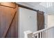 Upper hallway with double barn doors and white railing at 2511 Dolly Bay Dr # 308, Palm Harbor, FL 34684