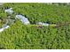 Aerial view showing condos nestled in a wooded area with a pond at 2511 Dolly Bay Dr # 308, Palm Harbor, FL 34684