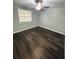 Well-lit bedroom, showcasing dark laminate flooring and a ceiling fan at 2013 Finland Dr, Spring Hill, FL 34609