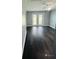 Bedroom with dark hardwood floors and double doors leading outside at 2013 Finland Dr, Spring Hill, FL 34609