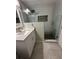 Modern bathroom with white vanity, glass shower, and hexagonal tile shower floor at 2013 Finland Dr, Spring Hill, FL 34609