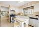 Efficient kitchen with white cabinets, stove, and breakfast bar at 13002 Wedgewood Way # D, Hudson, FL 34667