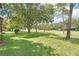 Spacious backyard with lush grass and mature trees, overlooking a golf course at 13002 Wedgewood Way # D, Hudson, FL 34667