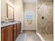 Bathroom with double vanity, granite countertops, and a tiled shower at 7332 Islander Ln, Hudson, FL 34667