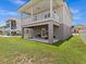 Two-story house with covered patio, grassy backyard, and partial water view at 7332 Islander Ln, Hudson, FL 34667