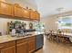 Open concept kitchen and dining area with granite countertops and wood cabinetry at 7332 Islander Ln, Hudson, FL 34667