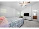 Main bedroom with large bed, TV, and access to en-suite bathroom at 27563 Pleasure Ride Loop, Wesley Chapel, FL 33544