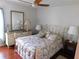Bedroom with floral bedding, dresser, and hardwood floors at 10526 Mira Vista Dr, Port Richey, FL 34668
