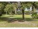 Landscaped backyard with lush trees and open space at 12709 Clock Tower Pkwy, Hudson, FL 34667