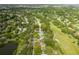 Aerial view of home nestled in a tree-lined neighborhood by golf course at 12709 Clock Tower Pkwy, Hudson, FL 34667