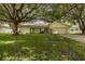 Single-story home with large oak tree and grassy yard at 12709 Clock Tower Pkwy, Hudson, FL 34667