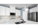 Modern kitchen with stainless steel appliances and white cabinetry at 8731 Starry Night Ter, Parrish, FL 34219