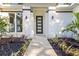 Inviting entrance with modern door, lush landscaping, and stylish outdoor lighting at 9229 Creston Ave, New Port Richey, FL 34654