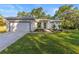Charming home with manicured lawn, featuring an attached garage and meticulously landscaped front yard at 9229 Creston Ave, New Port Richey, FL 34654