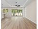 Spacious living room with wood floors, ceiling fan, and sliding glass doors to the outdoor patio at 9229 Creston Ave, New Port Richey, FL 34654