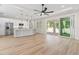 Open-concept living room with sliding doors to the outdoor area, bright lighting, and kitchen access at 9229 Creston Ave, New Port Richey, FL 34654