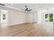 Bright living room with ceiling fan, neutral paint, wood flooring, and access to other rooms at 9229 Creston Ave, New Port Richey, FL 34654