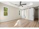 Bright main bedroom featuring a tray ceiling, modern fan, wood-look floors and barn-style doors at 9229 Creston Ave, New Port Richey, FL 34654