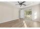Bright main bedroom featuring a tray ceiling, modern fan, wood-look floors and a sliding glass door at 9229 Creston Ave, New Port Richey, FL 34654