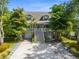 Two-story house with a gray exterior, white stairs, and lush landscaping at 758 Claudia Ln, Palm Harbor, FL 34683