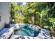 Relaxing pool area with a stone waterfall and tropical plants at 758 Claudia Ln, Palm Harbor, FL 34683