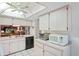 Kitchen with white cabinets, black appliances, and a breakfast bar at 3275 Lori Ln # 5, New Port Richey, FL 34655