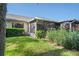 Private backyard with screened patio, landscaping, and grass at 3275 Lori Ln # 5, New Port Richey, FL 34655