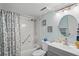 Updated bathroom with tub/shower, gray vanity, and patterned curtain at 3232 Lake Pine E Way # H2, Tarpon Springs, FL 34688