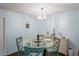 Charming dining area with round glass table and four teal chairs at 3232 Lake Pine E Way # H2, Tarpon Springs, FL 34688