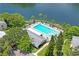 Aerial view of community pool, spa, and clubhouse near lake at 3232 Lake Pine E Way # H2, Tarpon Springs, FL 34688