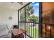 Screened lanai with table and chairs, and views of the surrounding area at 3232 Lake Pine E Way # H2, Tarpon Springs, FL 34688