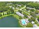 Aerial view of community with lake, pool, and building at 3232 Lake Pine E Way # H2, Tarpon Springs, FL 34688