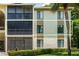 Exterior view of a condo building showcasing a balcony and surrounding landscaping at 3232 Lake Pine E Way # H2, Tarpon Springs, FL 34688