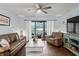 Living room with brown leather furniture, white coffee table, and sliding doors to balcony at 3232 Lake Pine E Way # H2, Tarpon Springs, FL 34688