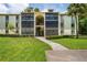 Two-story building with screened balconies and a landscaped lawn at 3232 Lake Pine E Way # H2, Tarpon Springs, FL 34688