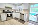 Modern kitchen with white cabinets, stainless steel appliances, and vinyl flooring at 9114 Richwood Ln, Port Richey, FL 34668