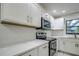 Modern kitchen featuring white cabinets, quartz countertops, and stainless steel appliances at 1423 Meadow Lark Rd, Spring Hill, FL 34608