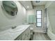 Bathroom with single vanity, shower/tub combo, and window at 1423 Meadow Lark Rd, Spring Hill, FL 34608