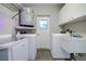 Bright laundry room features washer, dryer, and extra storage at 1423 Meadow Lark Rd, Spring Hill, FL 34608