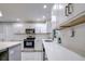 Modern kitchen with white cabinets, quartz countertops and stainless steel appliances at 1423 Meadow Lark Rd, Spring Hill, FL 34608