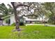 House exterior with large tree and lawn at 1423 Meadow Lark Rd, Spring Hill, FL 34608