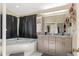 Bathroom with double sink vanity, soaking tub, neutral walls, and black curtains at 6096 Kinlock Ave, Spring Hill, FL 34608